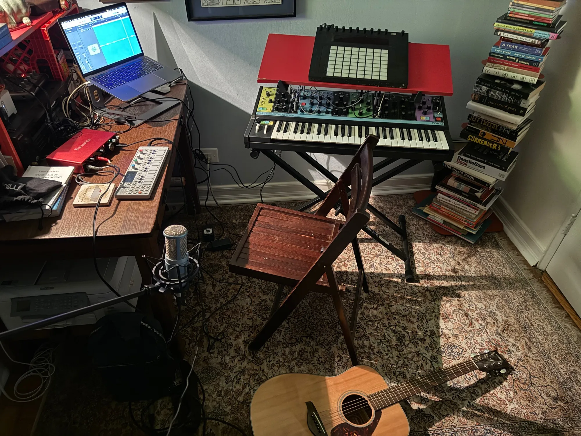 John Paul Davis's musical work space, with a MacBook running Ableton Live, a Moog Matriarch, an OP-1, a microphone and an acoustic guitar